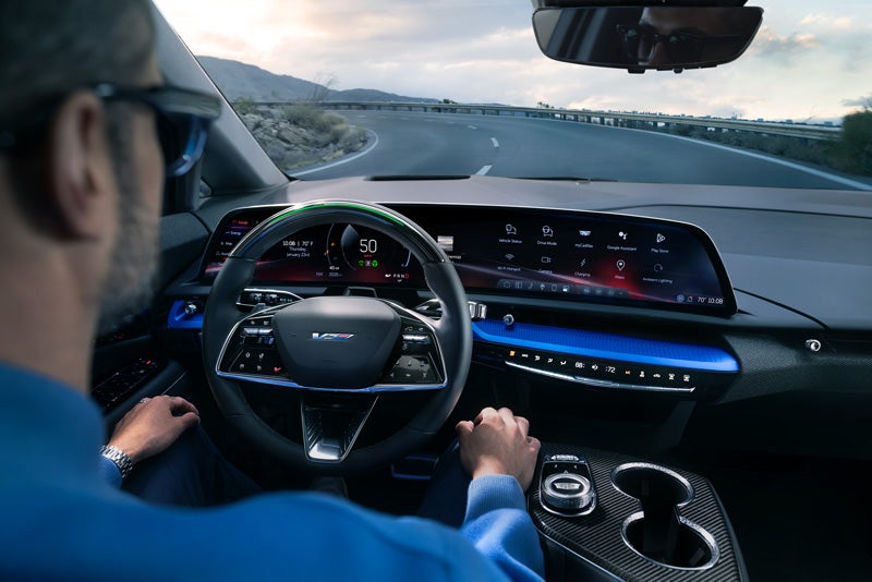 Front View of the 2026 OPTIQ-V Driving Through the Dusk Utilizing its Headlights | King Cadillac in FLORENCE SC